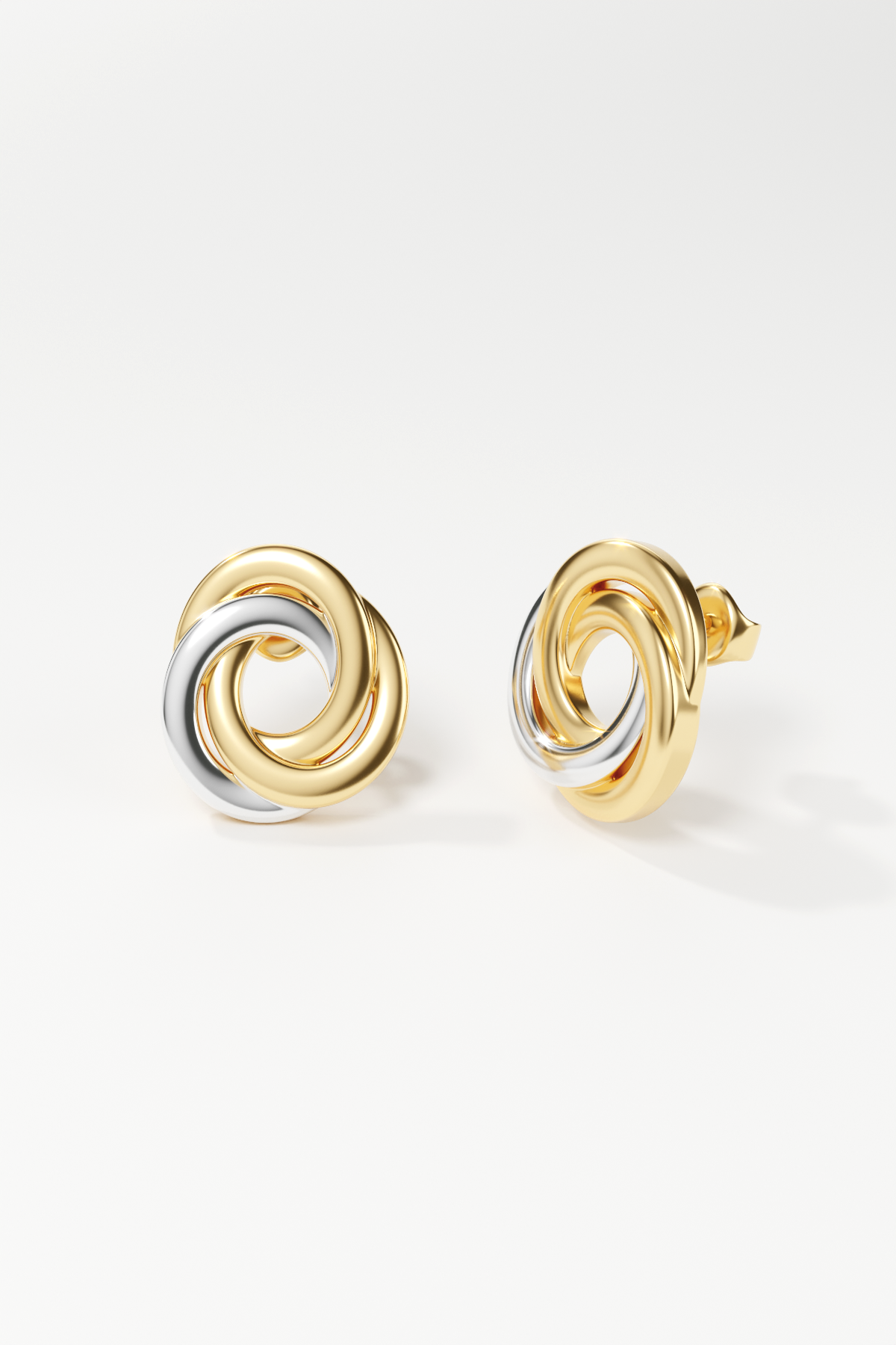 Pair of gold and silver spiral earrings on a white background