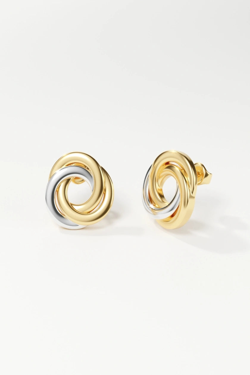 Pair of gold and silver spiral earrings on a white background