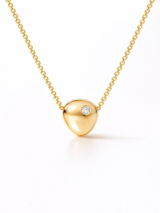 Gold necklace with a heart-shaped pendant on a white background